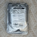 A sealed plastic bag of pasta on a beige patterned fabric background. The package label reads Pasta Fagioli and shows the Minute Meats logo and nutrition information.